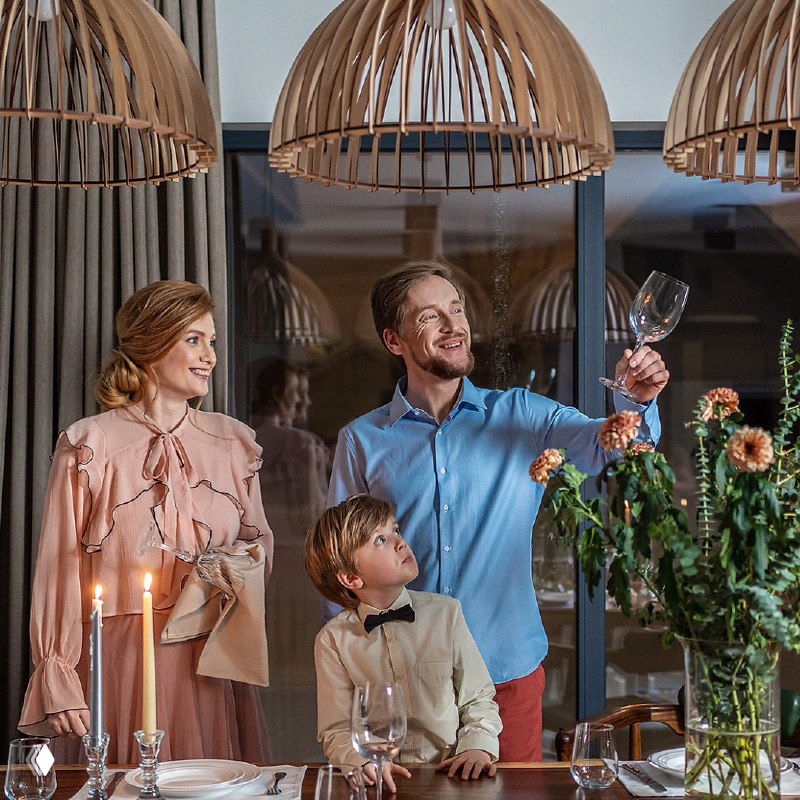 Семья празднует за столом возле больших окон — образ уюта и комфорта после замены окон, рекламная иллюстрация результата.