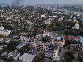 Вид на город Покровск/Красноармейск в Донбассе с разрушенными зданиями и дымом — контекст статьи о последствиях войны и обсуждении использования активов.