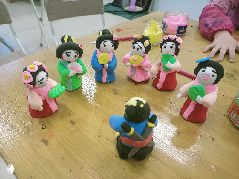 Набор маленьких пластилиновых фигурок в японском стиле — куклы и самураи, аккуратно лепленные и раскрашенные детьми на кружке лепки.