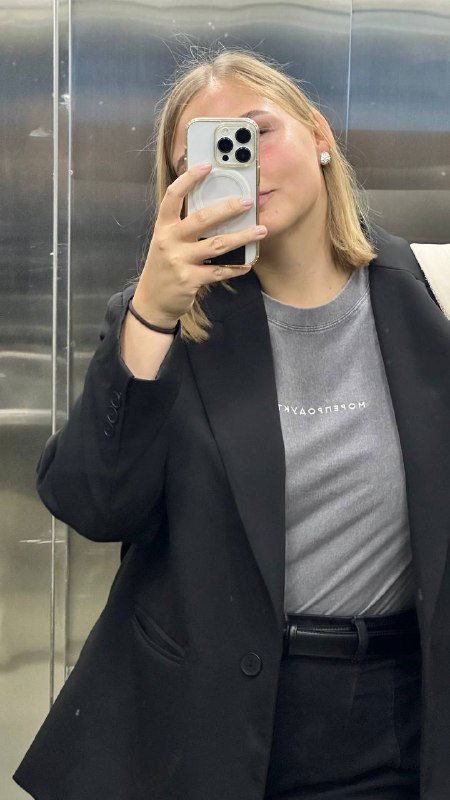 Фото в зеркале: серая футболка и черный пиджак, кадр показывает посадку футболки и сочетание с верхней одеждой для образа.