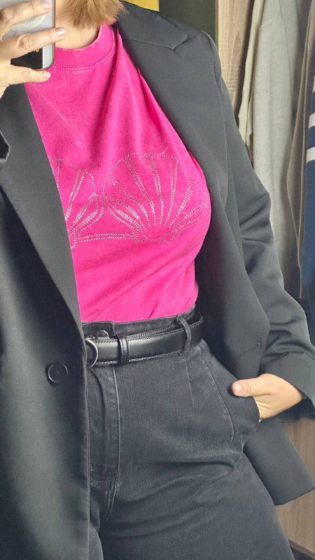 Крупный кадр розовой футболки с принтом ракушек из стразиков, видно текстуру ткани и блеск страз на принте.