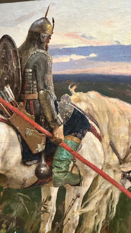 Фотография полотна на выставке Васнецова: всадник в латах и конь на фоне горизонта, переданы фактура щёлок и игры света на бронзе.