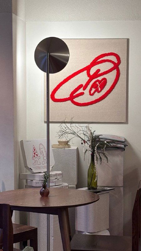 Интерьер пекарни с круглым столиком, вазой и оформлением стены: минималистичный дизайн и уютная атмосфера заведения Skrepka.