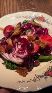 Овощной салат с тосканским кейлом, свёклой, брокколини и оливками на винтажной тарелке в боке ресторана — яркие краски блюда