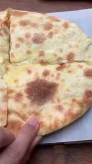 Разрезанный хачапури или шота пури с тянущимся сыром — видна текстура теста и сырная начинка, характерная для пекарни Bagebi.