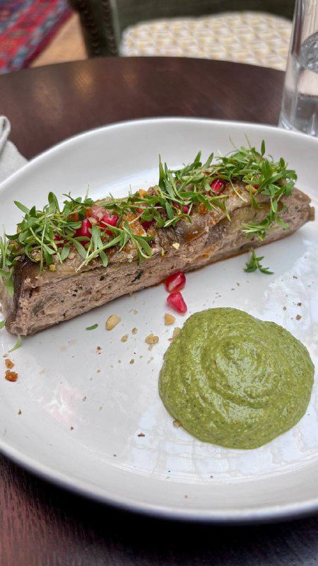 Длинная закуска из овощного паштета или баклажанной намазки, украшенная зеленью и соусом — современная интерпретация грузинских вкусов в Bagebi.