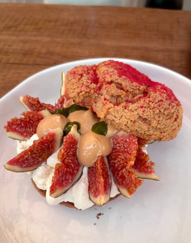 Десерт с кремом, свежими инжирами и хрустящей основой — авторская сладкая подача в меню Bagebi, фотография крупным планом.