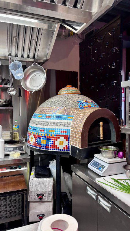 Кухонная печь с мозаичной облицовкой в ресторане Kilim: рабочая зона, декор печи и элементы для выпечки лепёшек и блюд на дровах.