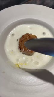 Процесс сервировки: создание пены и финальные штрихи у тарелки с гребешком, демонстрация техники подачи и внимания к деталям.