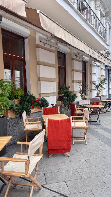 Уличная терраса перед входом в бистро: столы, кресла и текстильные акценты у фасада на Пречистенке, вид с улицы на заведение.
