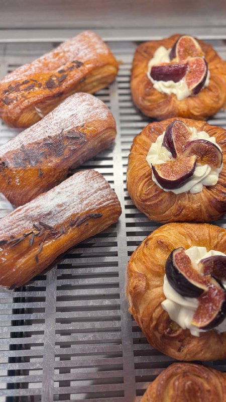 Ближе к витрине: даниш с инжиром и рулеты — текстура теста и крема хорошо видна, выпечка выглядит свежей и аппетитной.
