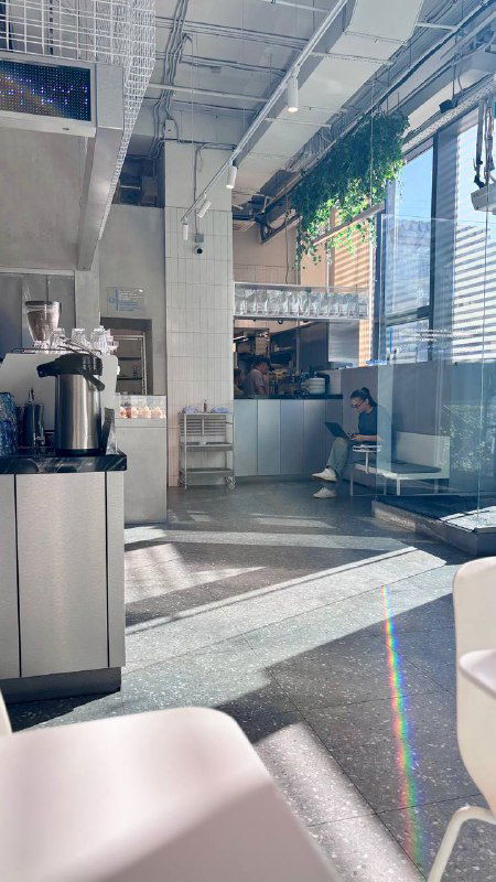 Интерьер rockets: светлый зал с высокой потолочной структурой, большими окнами и минималистичным оформлением — вид изнутри кафе.