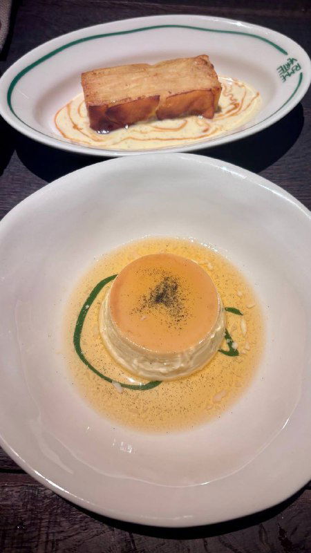 Два небольших блюда на белых тарелках: ломтик хлеба и кремовая подложка, аккуратная подача в минималистичном стиле высокой кухни.