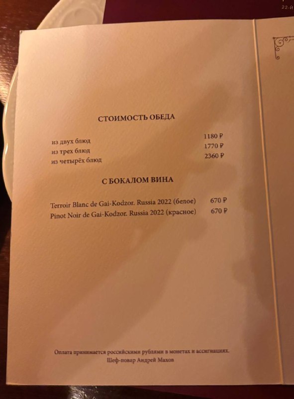 Разворот меню ресторана «Пушкинъ» с печатным текстом о стоимости обеденного набора и позициями винной карты, снимок крупным планом страниц.