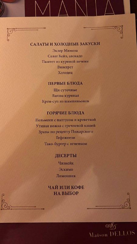 Страница меню с перечислением салатов, горячих блюд и десертов — видна типографика и разделы, снимок вертикальный на столе ресторана.