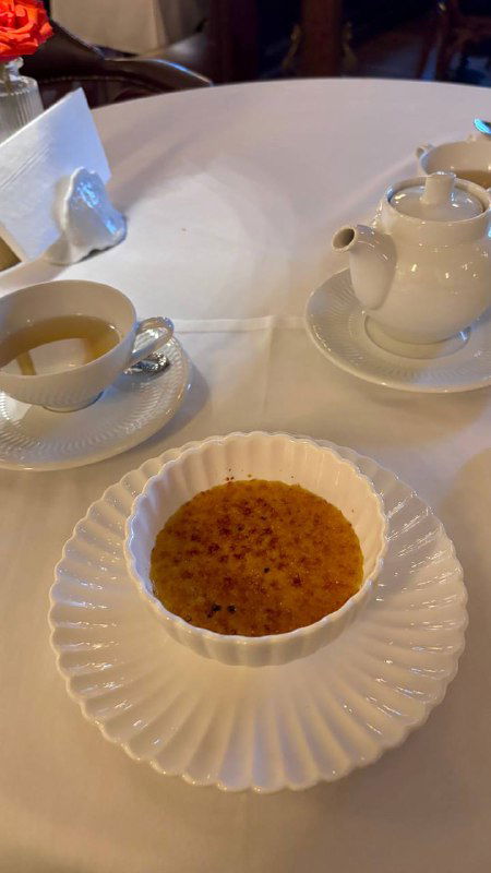 Десерт и чаепитие в Шануар: крем-брюле в белой посуде, рядом чайник и чашка на столе, тёплая приятная сервировка ресторана.