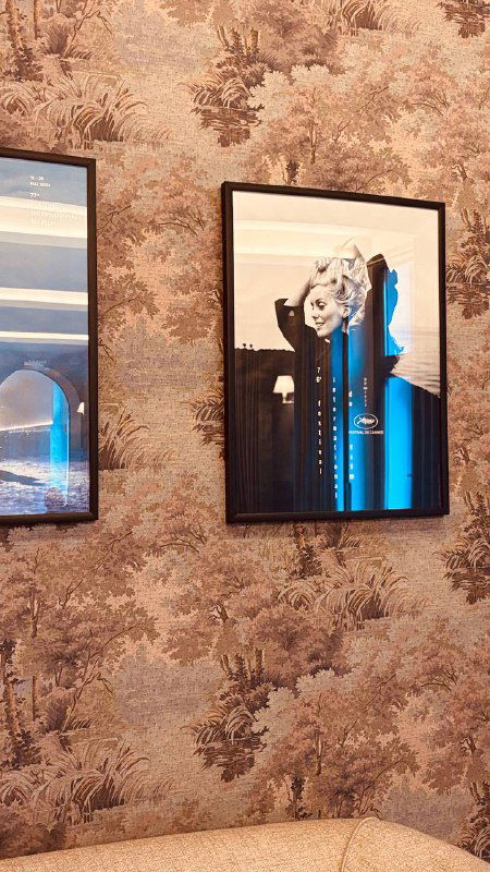 Детали оформления стен: картины в рамках на фоне декоративных обоев, элемент интерьерного дизайна исторического кинозала и фойе.