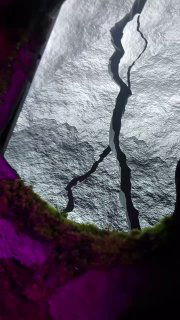 Текстурная поверхность с трещиной и фиолетовой подсветкой — элемент экспозиции, имитирующий пейзаж или карту с геометрическими акцентами.