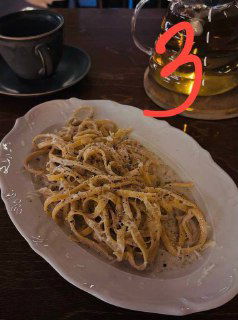 Тарелка с тонкой пастой, посыпанной тёртым сыром и чёрным перцем — паста №3 в подборке московских заведений, тёплый интерьер.