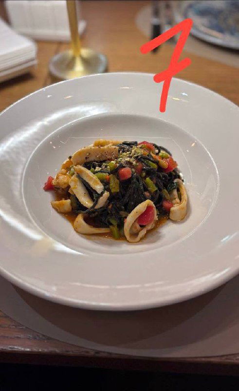 Небольшая порция пасты с морепродуктами и тёмным соусом — паста №7 в подборке, видна структура ингредиентов и сервировка.