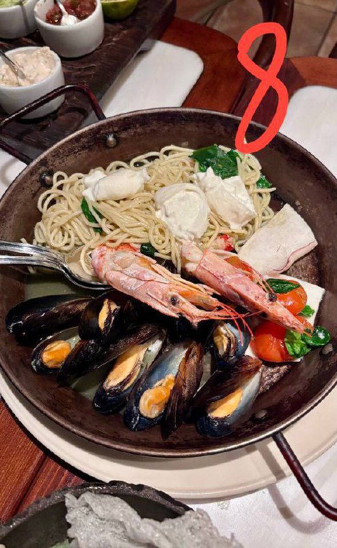 Большая тарелка с ассорти из морепродуктов и лапшой — паста №8, богатая подача с креветками и мидиями, ресторанная подача.