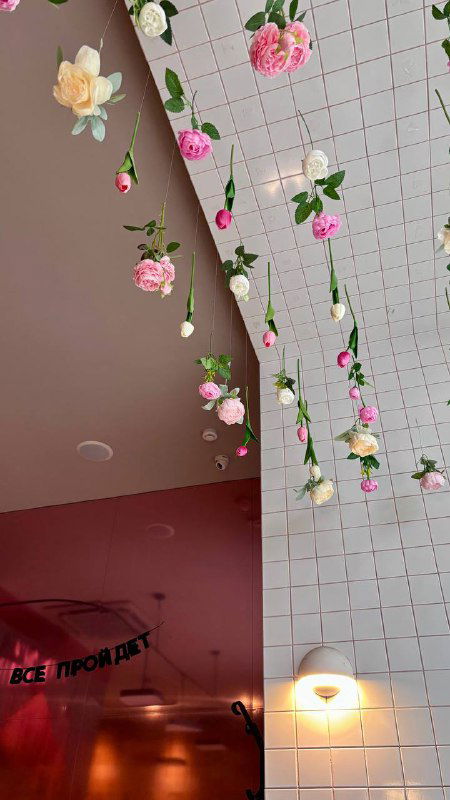 Потолок кафе с висящими искусственными цветами и плиточной отделкой, вид на декоративный розовый интерьер Balik.