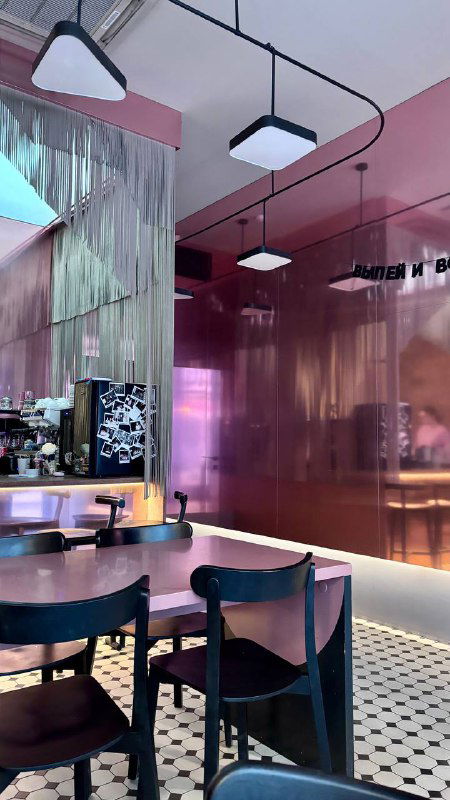 Интерьер кафе Balik: розовые зеркальные панели, столы и стулья, мягкое освещение и современная мебель, вид изнутри.