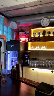 Ещё один угол бара с яркой цветовой подсветкой, холодильником и декоративными предметами — интерьерное фото в ретро‑вайбе Ростова.
