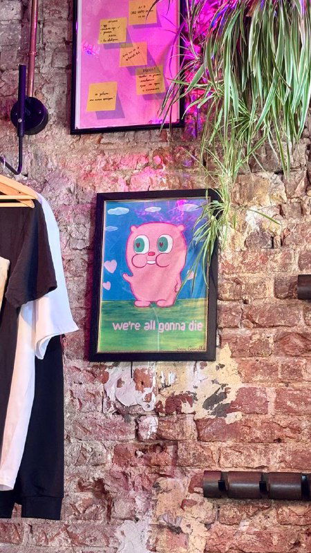 Постер с мультяшным персонажем на кирпичной стене кафе Mission, рядом висят заметки и элементы интерьера в розовой подсветке.