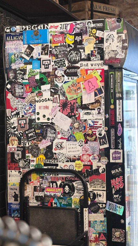 Холодильник или поверхность, усыпанная наклейками и стикерами — эффектная стена с графикой и уличными наклейками в кафе Mission.