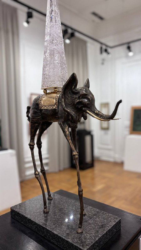 Скульптура слона на длинных тонких ногах в стиле Сальвадора Дали, металлическая фактура и постамент, интерьер выставочного зала