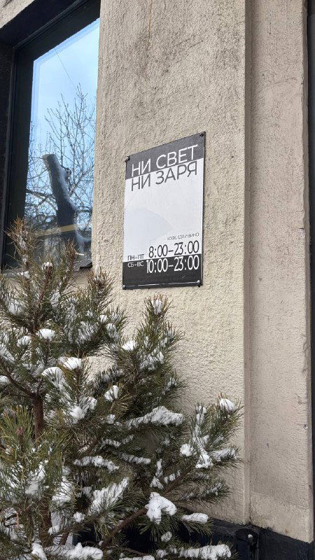 Фасад кофейни с табличкой «Ни свет ни заря» на стене, снег у входа — уличный вид заведения на Улице Покровка в Москве.