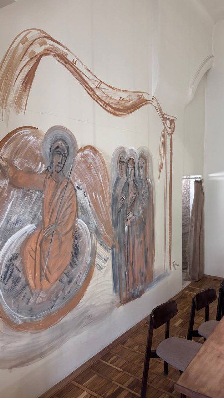 Фрагмент настенной росписи с иконописными мотивами на фоне светлой стены внутри трапезной при монастыре, художественная роспись.