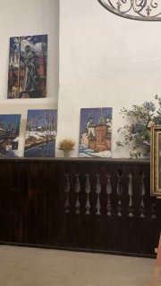 Стена с картинами и декоративными элементами в трапезной, настенные работы и детали интерьера в религиозном пространстве.