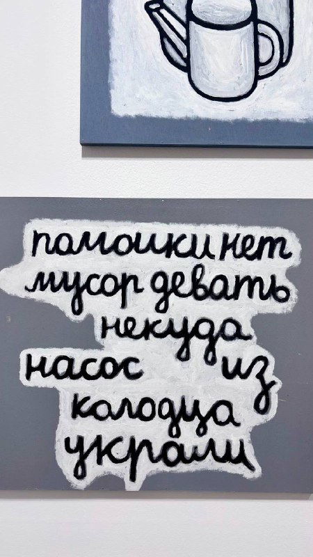 Фрагмент текстовой работы с рукописной кириллицей: надпись на сером фоне, читаемая как элемент художественного высказывания экспозиции.