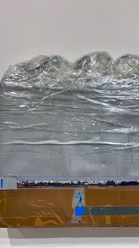 Панорамный фрагмент работы с объёмной серебристой фактурой и горизонтальными слоями, установленной на небольшой подиум в зале.