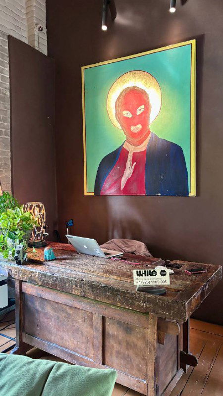 Комната с яркой поп-арт картиной над ретро-столом, приёмная зона с декоративными предметами и зеленью, интерьерный акцент.