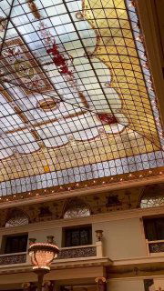 Вертикальный ракурс интерьера отеля Метрополь: витражная крыша, балконы и архитектурные детали в стиле модерн, высокое пространство