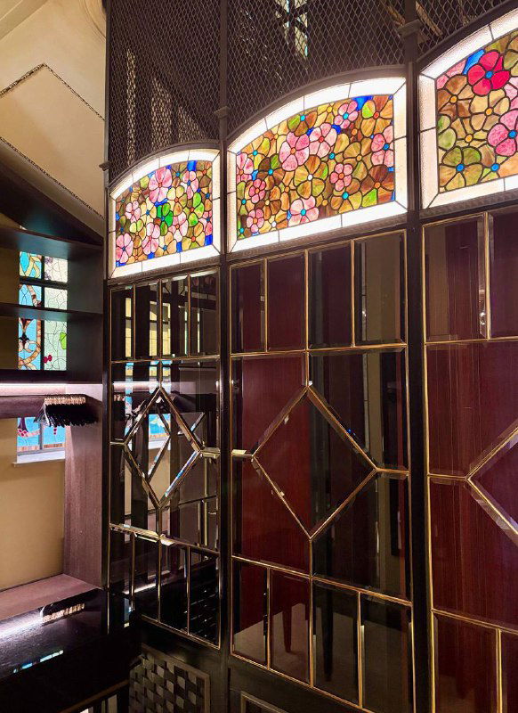Интерьерный фрагмент с витражными окнами и декоративными дверными решётками в отеле Метрополь — сочетание стекла и металла в стиле начала XX века