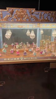 Миниатюрная сценка с фигурками в витрине механического театра — игровые фигурки и крошечные декорации в защищённом стеклом шкафу.