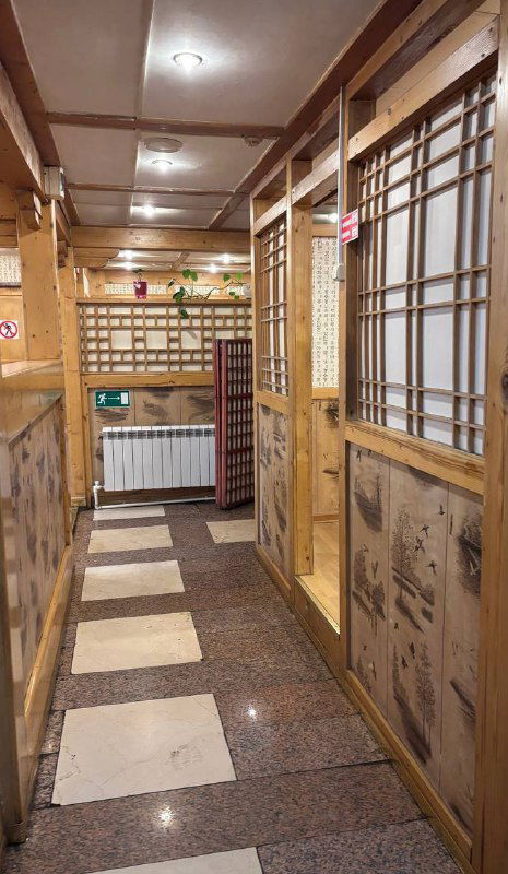 Узкий коридор внутри заведения с деревянными перегородками и небольшими кабинками для посетителей — типичная атмосфера некоторых корейских точек.