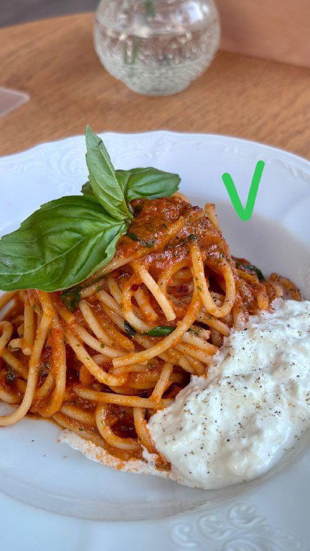 Паста в томатном соусе с крупной порцией рикотты и листом базилика, белая тарелка и отметка галочкой — попала в список лучших.