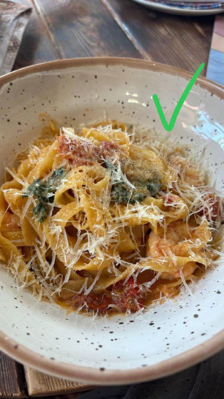 Тальятелле с тёртым сыром и томатами, крупный план блюда на керамической тарелке, видна отметка галочкой — финалист рейтинга.