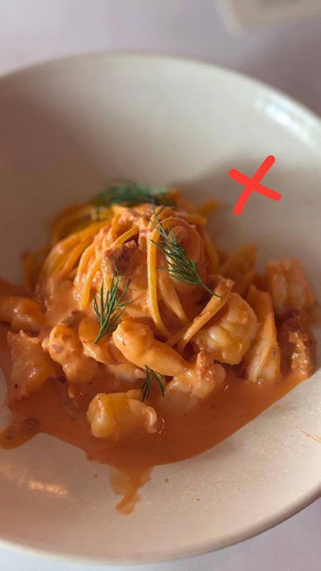 Паста в розовом соусе с кусочками морепродуктов, тёплая сервировка, на фото красный крест — блюдо не прошло в финал исследования.