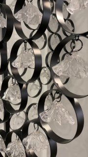 Ещё один крупный план металлической инсталляции с прозрачными стеклянными элементами, отражающими свет в музейном интерьере.