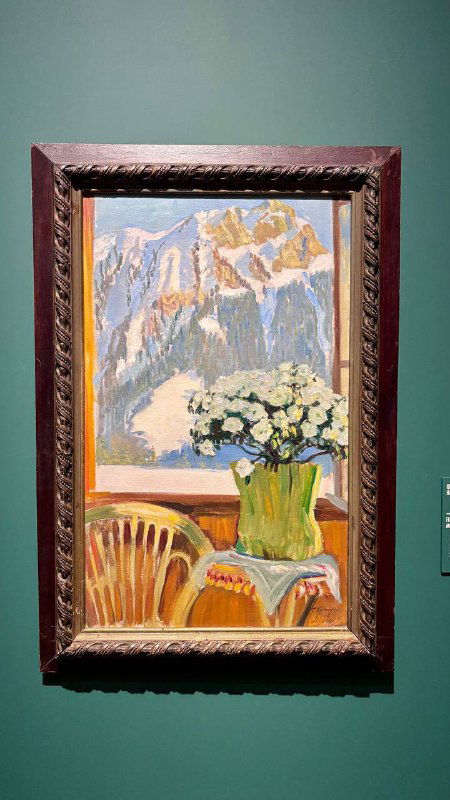 Пейзаж с вазой и горным фоном: яркие мазки, контрастный натюрморт на фоне гор и оформленная рама на стене музея.