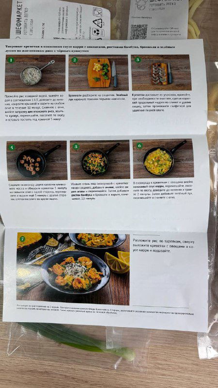 Лист с пошаговой инструкцией и фотографиями рецепта Шефмаркет в пластике, рядом зелёный лук — пример карточки с инструкциями для набора