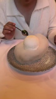 Белый сферический десерт подают на тарелке с узором — авторский десерт ресторана Christian, текстура и подача подчёркивают концепцию заведения в Москве