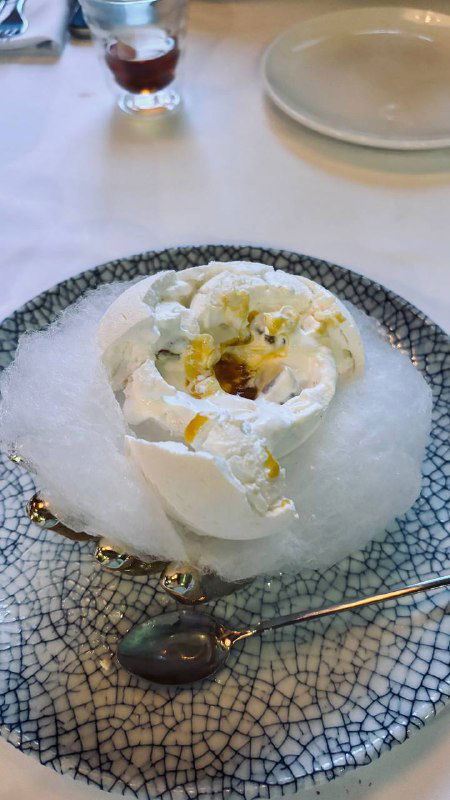 Десерт с воздушной сахарной подачей в форме цветка на тарелке — креативная сладкая позиция в меню ресторана Christian на Кутузовском