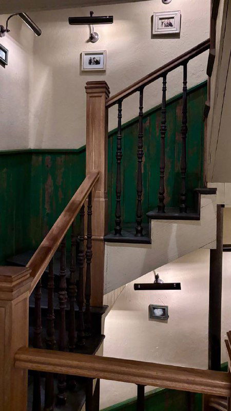 Деревянная лестница и зелёные перила внутри ресторана Christian — архитектурная деталь интерьера, видимая в авторском обзоре заведения в Москве